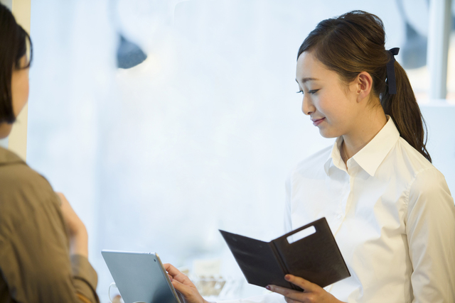 日付のない領収書を発行する店員のイメージ